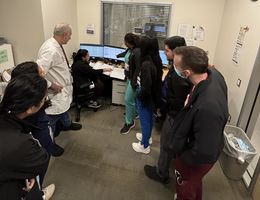 Dr. Bannout, in a white coatm with a group of students and residents during a teaching session about seizures 