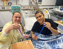 Child life assistant and patient play with slime they made at the patient bedside
