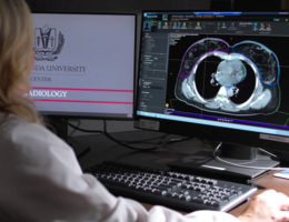 A woman looks at a computer screen with a medical scan