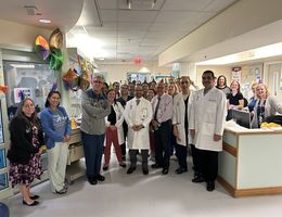 Doctors and treatment team stand smiling as they celebrate the introduction of CAR T therapy at LLUH