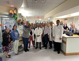 Doctors and treatment team stand smiling as they celebrate the introduction of CAR T therapy at LLUH