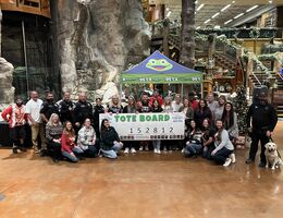 Volunteers and participants gather for a check presentation