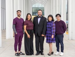 infectious disease team of three men and two women standing outside