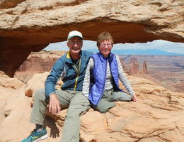 Caucasian couple in their 60s atop a giant rock in the daylight