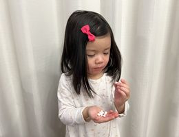 Young girl holding candy that looks like medication in her hands