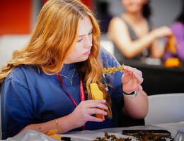 female sitting at a table wearing a navy shirt studying a specimen