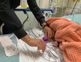 A nurse in the pediatric emergency department at LLU Children’s Hospital checks the blood pressure of a baby with RSV. Baby's foot used to check blood pressure by nurse in hospital
