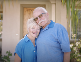 a woman and man smile together while holding each other