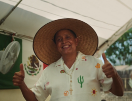 Patient jose Espinoza wearing a hat is facing the camera giving two thumbs up 