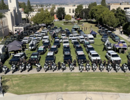 Aerial view of the Loma Linda University campus north lawn filled with rows of police vehicles, motorcycles, and officers from various Southern California law enforcement agencies during the 24th Annual Cops for Kids Fly-In event.