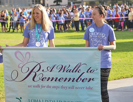 Two participants hold a banner for the "A Walk to Remember" event