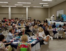 Wide shot of event space filled with guests sitting at their tables and officers lined up by the kitchen