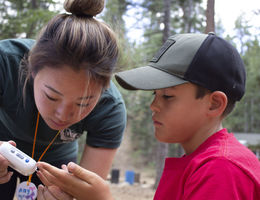 Amy Myung Song, a fourth year student at LLU School of Pharmacy, helps camper Cole Hoelker test his glucose level at Camp Conrad Chinnock on July 24.