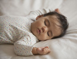 Mixed race baby girl sleeping on bed