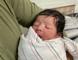 new years baby wrapped in bundle being held by dad