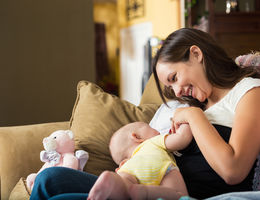 mom bonding with young baby on couch