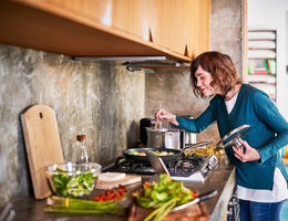 woman in the kitchen smelling her cooking food
