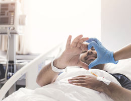 patient making heart shape out of fingers with doctor