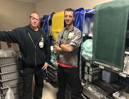 two nurses stand with medical carts called disaster carts