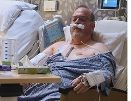 a man is sitting in a hospital care recovering from heart surgery