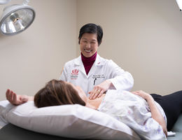 Dr. Lum performs a breast exam on a patient