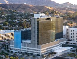 LLU hospital exterior at sunset with hills in the background