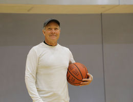 Enrique Gonzalez continues to play recreational sports after a minimally invasive back surgery. Enrique Gonzalez smiling, holding a basketball