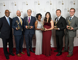 On the red carpet with their Emmy Awards, from left: Garrett Caldwell, Michael Wolcott, James Pendorf, Keturah Reed, Patricia Kelikani, Cosmin Cosma and Erik Edstrom. Group photo of Advancement Films members accepting their Emmy Awards
