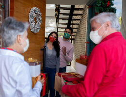 Parents visiting children for the holidays and everyone is wearing a mask
