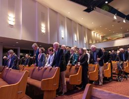 individuals standing in prayer in a chapel