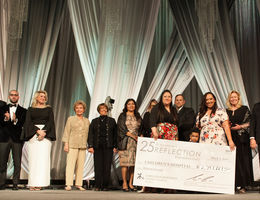 Group of people hold very big check