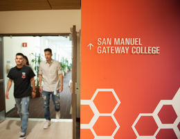 College interior signage with students walking by