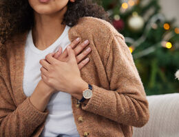 a woman uses both hands to hold her chest