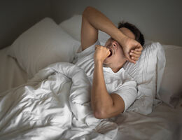 Tired man yawning and waking up early morning