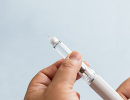 woman preparing a GLP-1 semaglutide injection pen at home.