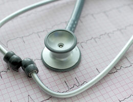 a stethoscope lays over medical paper