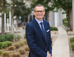 Dr. Hilliard wearing a blue suit and smiling at the camera 