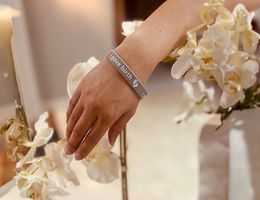 close up of a woman wearing an "I gave birth bracelet" arounod her wrist