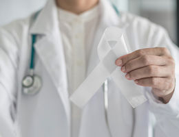 Physician holding white ribbon for lung cancer awareness 
