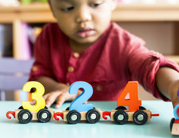 Little boy playing mathematics wooden toy at nursery