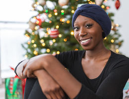 Woman with headscarf sitting in front of Christmas tree
