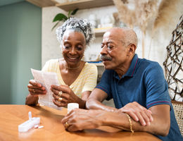 Older couple reading paper at table