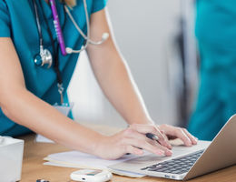 Women physician typing on computer