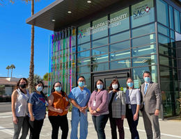 group of physicians and staff stand in front of clinic facility