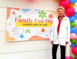 A colorful “Family Fun Day” banner displayed outdoors next to balloons at the event entrance.