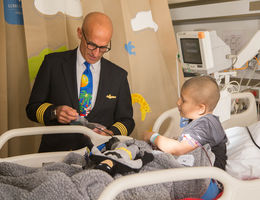 male pilot gives gifts to cancer patient