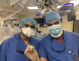Cardiologists Harit Desai, MD (left), and Niraj Parekh, MD (right), and hold up an artificial heart valve used to replace diseased valves of patients during TAVR (transcatheter aortic valve replacement) procedures. 