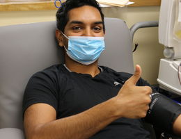 male sitting in chair giving blood