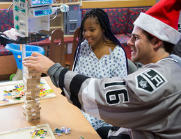 hockey player plays jenga with teenage female patient