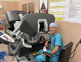 Dr. Le sits at the surgical robot's console,  where he performs minimally invasive chest surgeries on patients